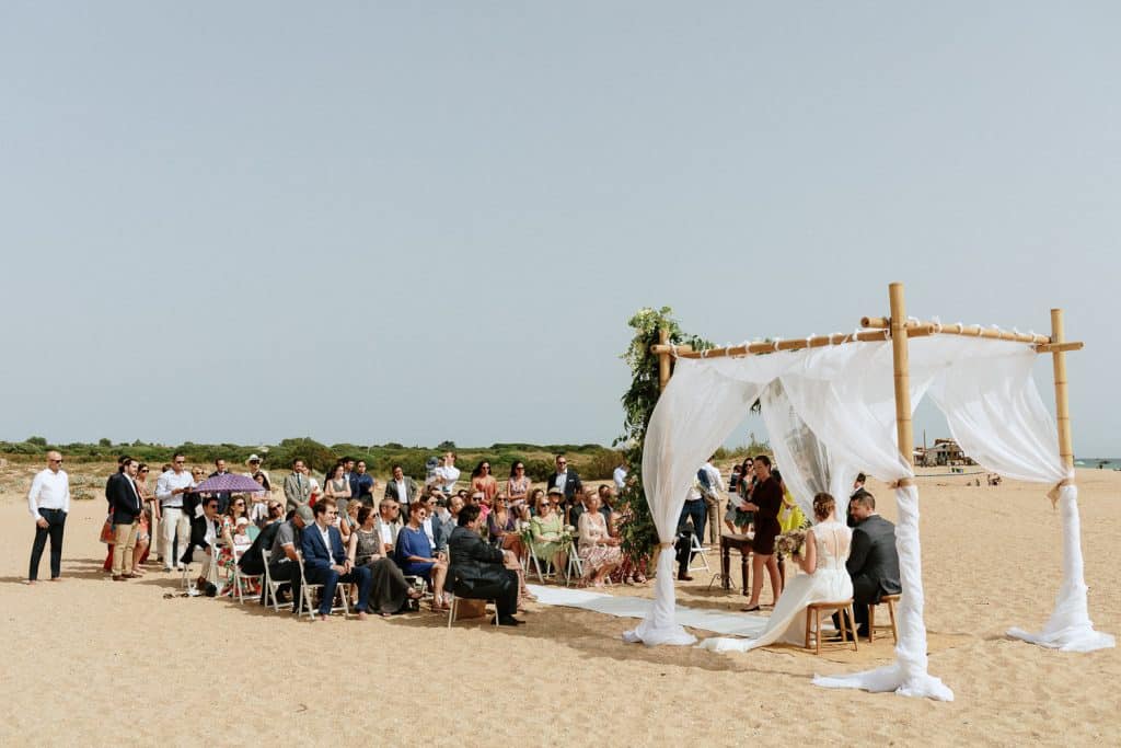 Boda en la playa con invitados al aire libre.